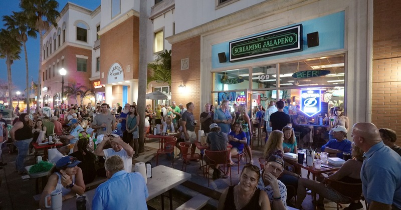 Outdoor seating area by night full of guests chatting and enjoying drinks