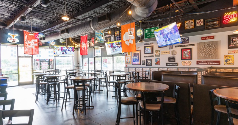 Dining and bar area, tables and chairs, TV screens