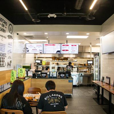 Interior featuring a counter with a menu board above the kitchen area.