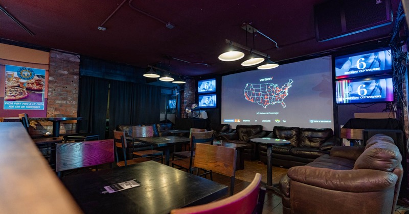 Interior, lounge seating area, projection screen and wall TVs
