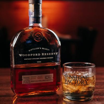 A bottle and glass of Woodford Reserve bourbon whiskey.