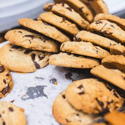 Freshly baked chocolate chip cookies arranged on a tray with parchment paper.