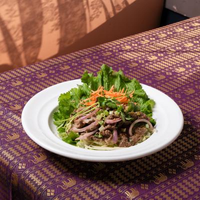 Grilled beef salad with red-green onions, cilantro, mints, and ground rice.