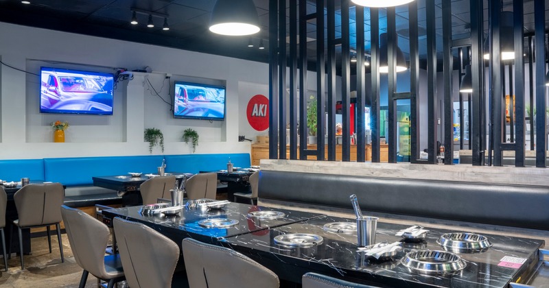 Modern restaurant interior with black marble tables with built-in grills