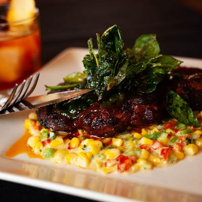 Crown Roast Pork with spinach and corn succotash.