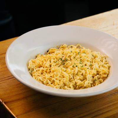 Cooked instant noodles in a white bowl.