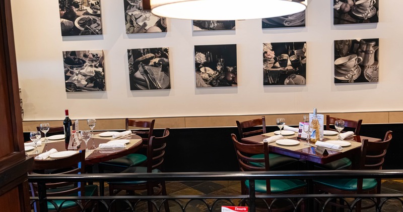 A restaurant interior with set dining tables and wall mounted photographs