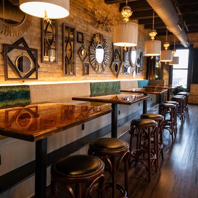 Banquette by a wall decorated with various mirrors and frames.