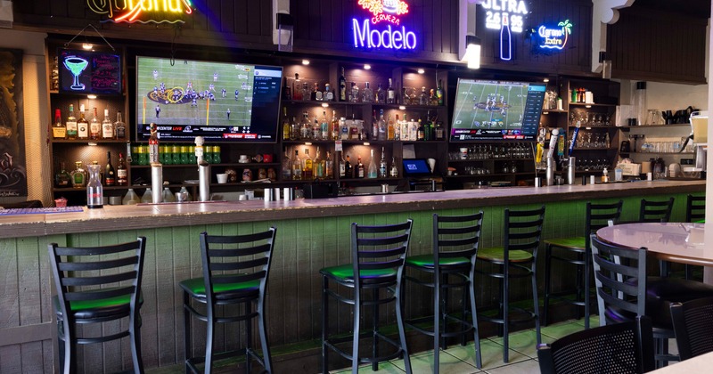 Interior, bar with stools and neon signs