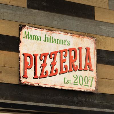 Interior, a wall mounted retro sign reading Mama Julianne's Pizzeria.