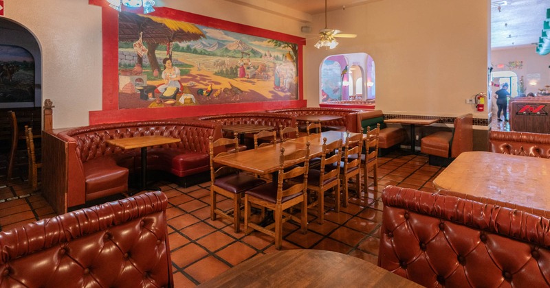 Interior seating area, paintings, leather booths, tables and chairs