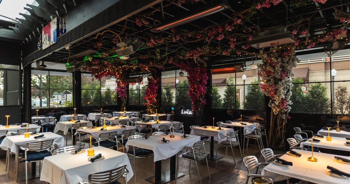 Elegant, semi-outdoor dining area with flower decorations on the ceiling