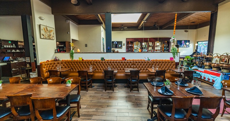 A cozy restaurant featuring wooden tables and chairs arranged for dining