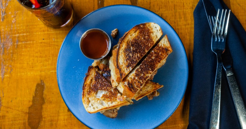 Top-down view of a pork grilled cheese sandwich with dipping sauce