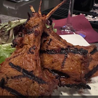 A serving of grilled lamb chops with greens.