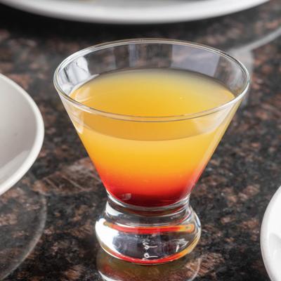 Layered orange and red cocktail in a stemless martini glass.