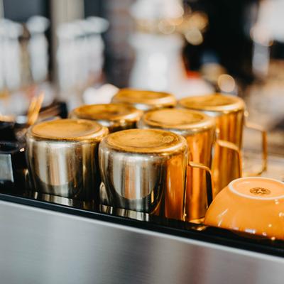 Stainless steal milk frothing pitchers displayed on the espresso machine.