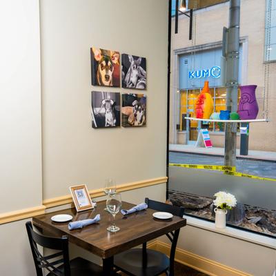 Corner dining table, fully set, pictures of dogs on the wall.