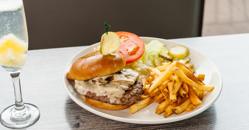 Mushroom Swiss Burger served with fries and a salad