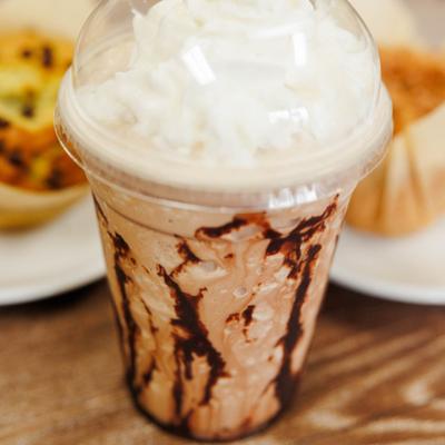 Mocha frappe with whipped cream in a plastic cup.