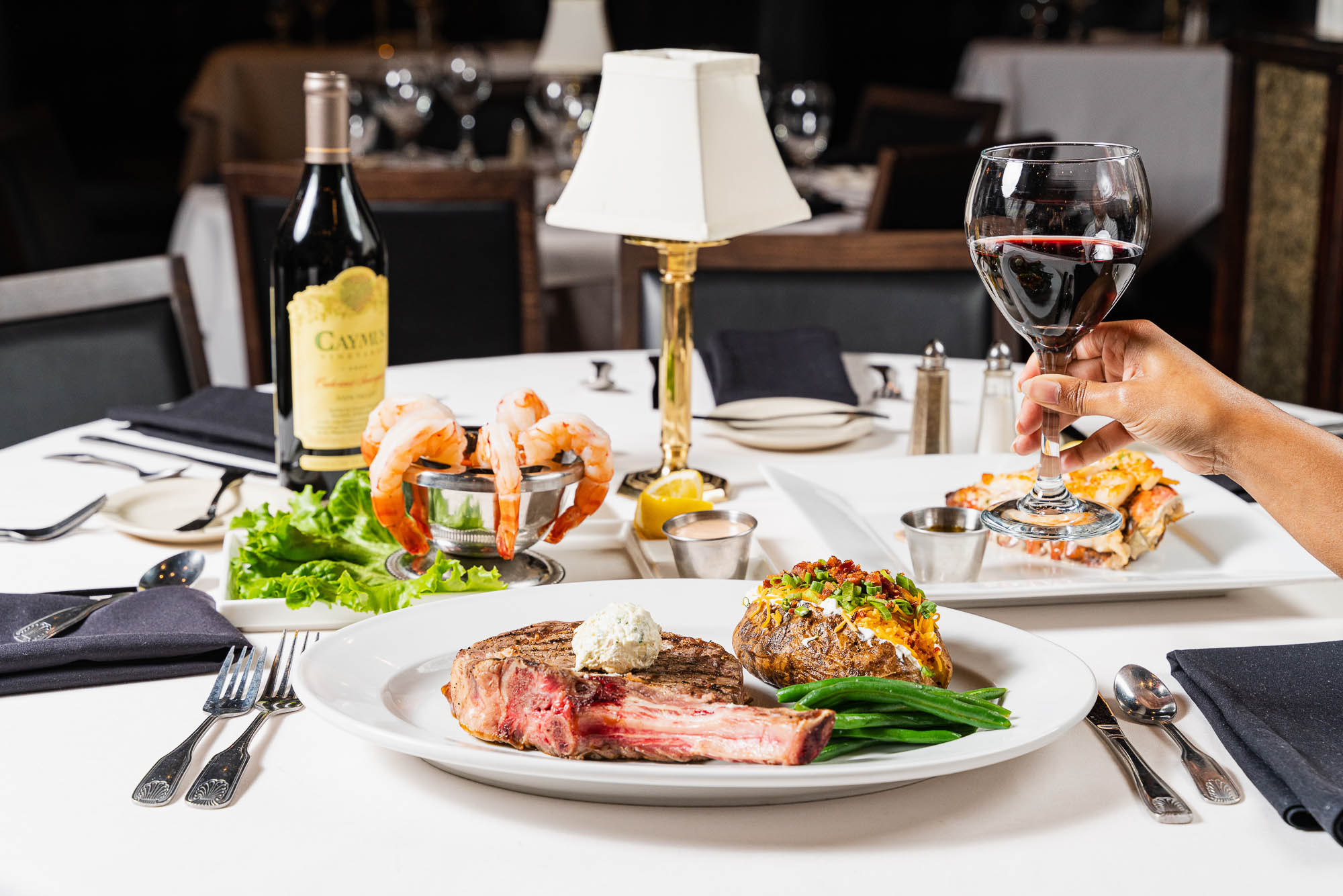 Prime bone-in rib eye with butter, loaded potato and green beans, served