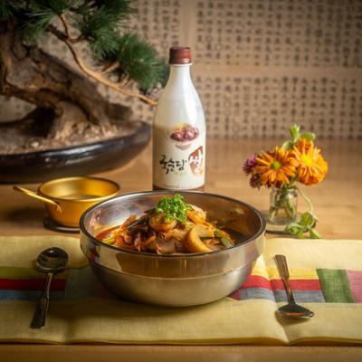 Seafood soup served with a bottle of rice vine.