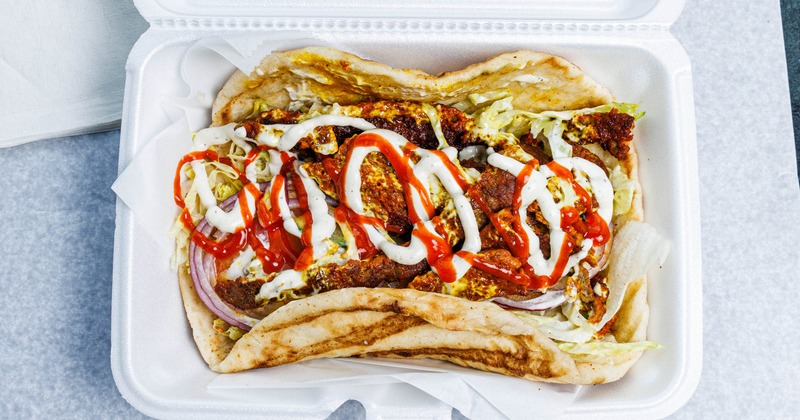 Lamb Gyro with lettuce, tomatoes, onions and drizzle of sauces