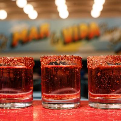 Three rimmed shots of Paleta served on the bar counter.
