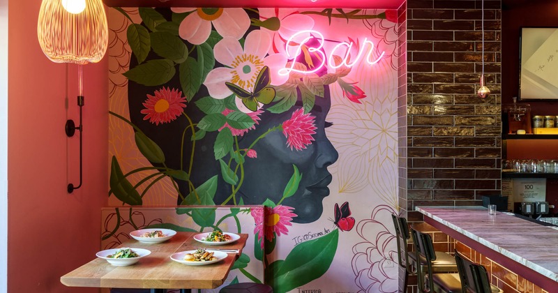 Interior, bar area, a table with served dishes, wall mural with floral motifs