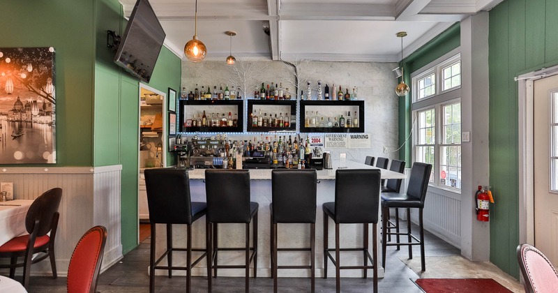 Interior, tables and chairs all lined up with glasses and tableware