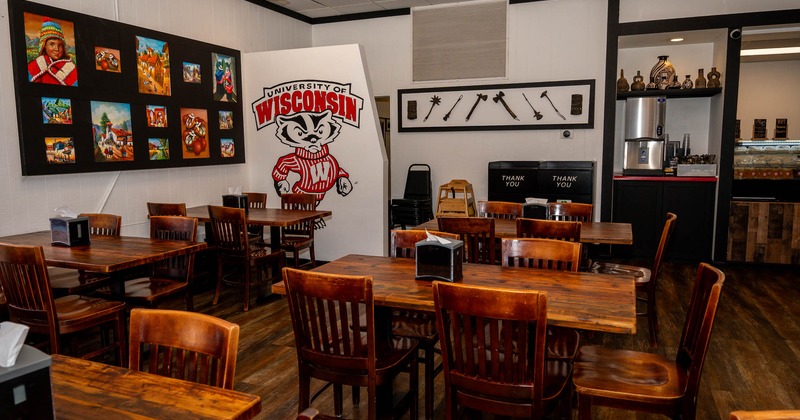 Interior, tables and chairs ready for guests with pictures on the wall