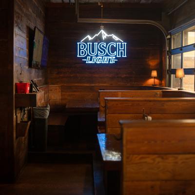 Interior, diner area, wide view, booths, light sign on the wall.
