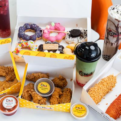 Korean street food spread featuring fried chicken, corn dogs, donuts, and boba.