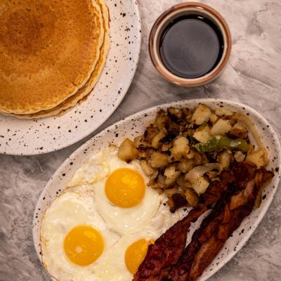 The Golden Eggs Special, three eggs, bacon, seasoned home fries, two pancakes, coffee.
