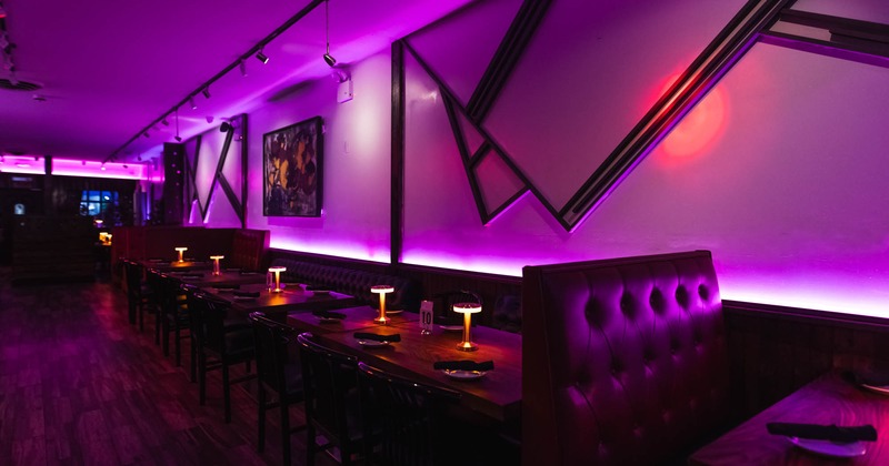 Interior, dining area, banquette bench with tables and chairs, seating booth, violet neon light