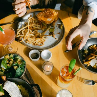 A full table, hands holding food.