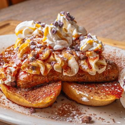 French toast topped with whipped cream, cocoa powder, and chocolate chips.