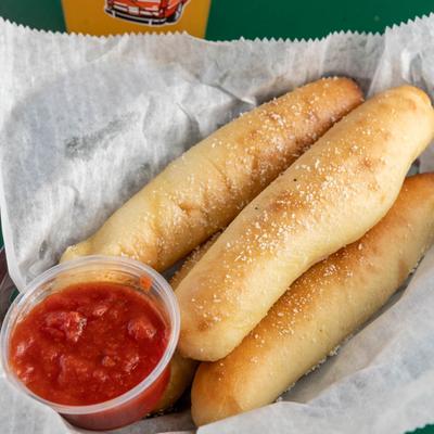 Toasted breadsticks served with marinara sauce on the side.