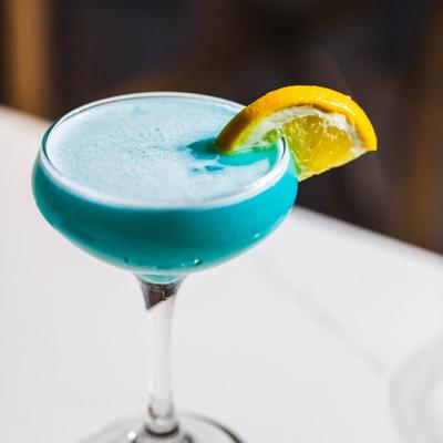 Blue Lagoon cocktail garnished with lemon wedge.