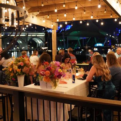 People seated on a waterfront patio at night.