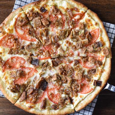 Sausage and tomato pizza with melted cheese and crispy bread topping.
