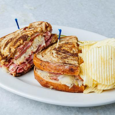 Reuben sandwich with potato chips.