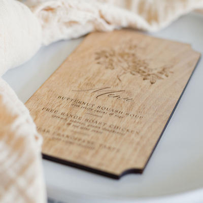 Elegant wooden menu card on a white table, close up
