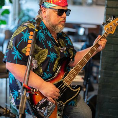 Interior, a musician playing bass guitar.