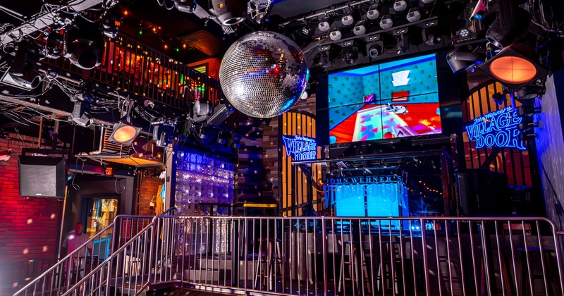 Multi-level interior featuring a large central disco ball and industrial-style lighting