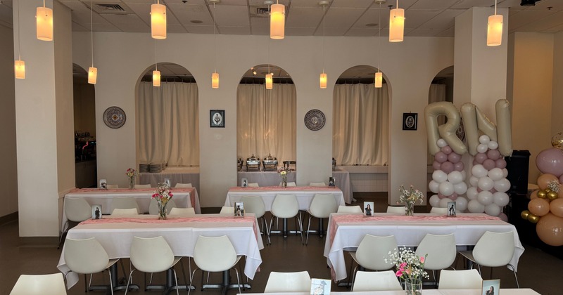 A room set up for an event, with tables, chairs, and decorations