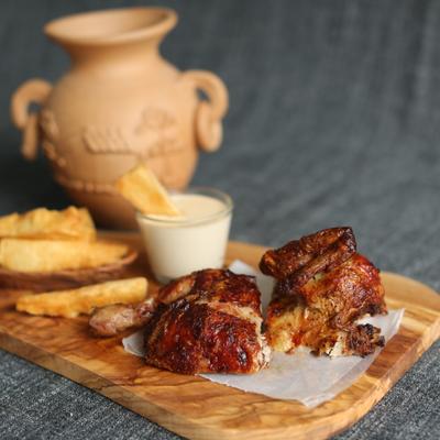 Roast chicken served with yuca fries and a creamy sauce dip.