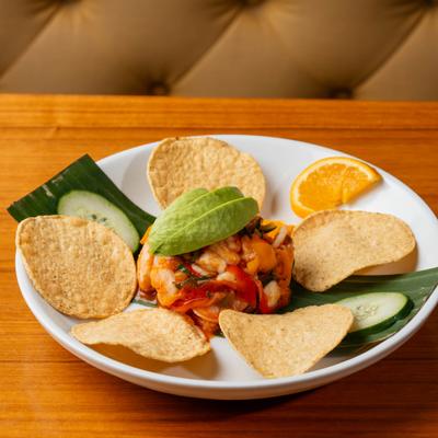 Ceviche made of shrimp, fish and scallops with avocado slices.