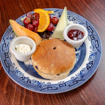 Tea cake served with fresh fruit, jam, and cream.