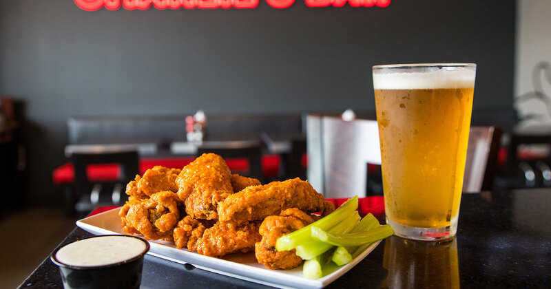 Dining area, hot wing plate with celery and sauce, served with beer